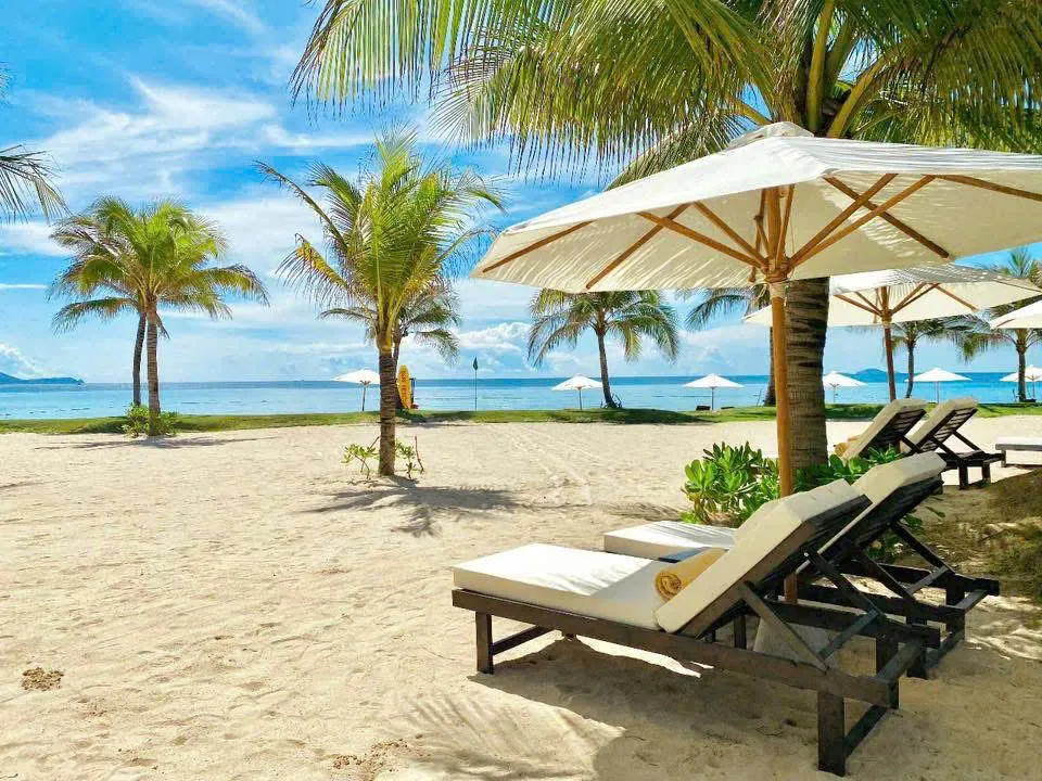 Bãi biển riêng với ghế nằm và dù trắng