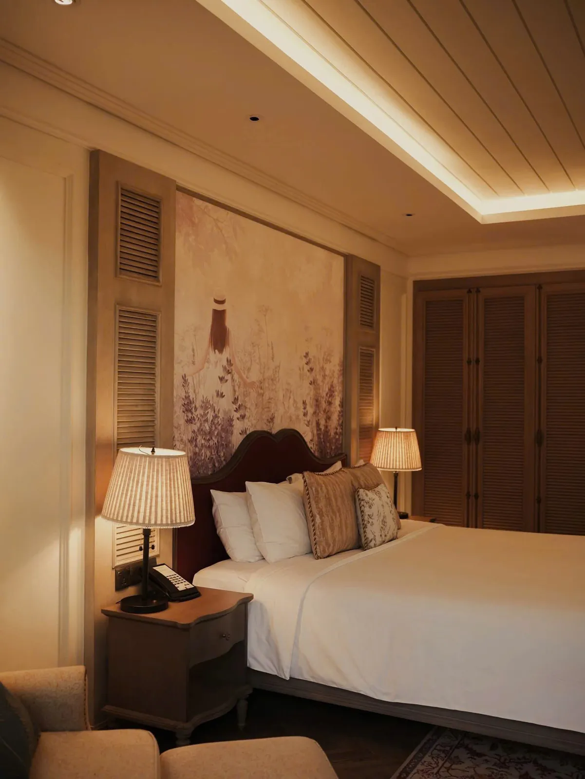 Phòng ngủ tông ấm với đèn ngủ và tranh hoa oải hương